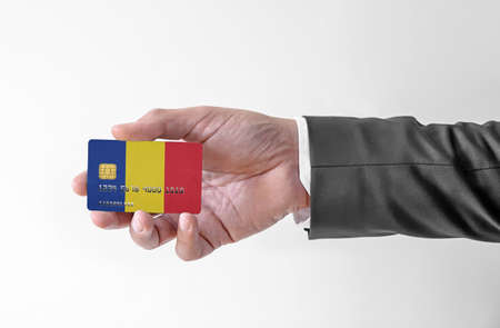 Bank credit plastic card with flag of Romania holding man in elegant suitの写真素材