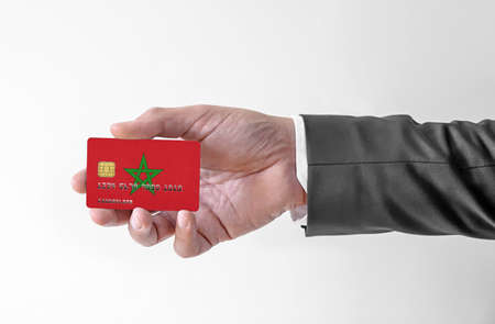 Bank credit plastic card with flag of Morocco holding man in elegant suitの写真素材