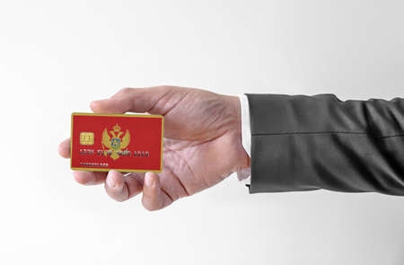 Bank credit plastic card with flag of Montenegro holding man in elegant suitの写真素材