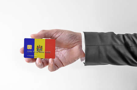 Bank credit plastic card with flag of Moldova holding man in elegant suitの写真素材