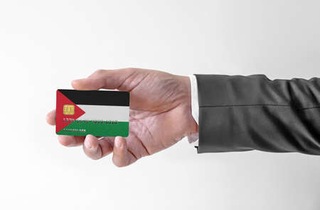 Bank credit plastic card with flag of Palestine holding man in elegant suitの写真素材