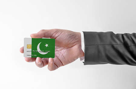 Bank credit plastic card with flag of Pakistan holding man in elegant suitの写真素材