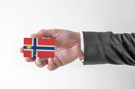 Bank credit plastic card with flag of Norway holding man in elegant suitの写真素材