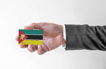 Bank credit plastic card with flag of Mozambique holding man in elegant suitの写真素材