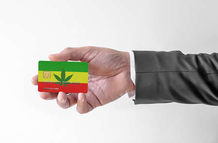 Bank credit plastic card with flag of Rassta holding man in elegant suitの写真素材