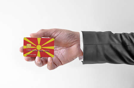 Bank credit plastic card with flag of North Macedonia holding man in elegant suitの写真素材