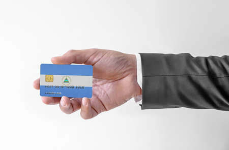 Bank credit plastic card with flag of Nicaragua holding man in elegant suitの写真素材
