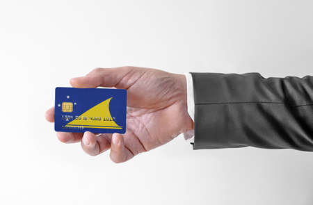 Bank credit plastic card with flag of Tokelau holding man in elegant suitの写真素材