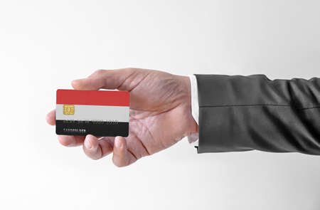 Bank credit plastic card with flag of Yemen holding man in elegant suitの写真素材