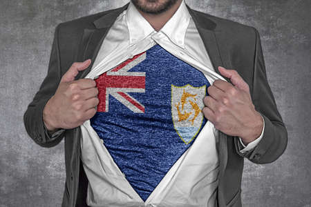 Business man show t-shirt flag of Anguilla rips open his shirtの写真素材