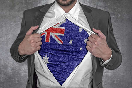 Business man show t-shirt flag of Australia rips open his shirtの写真素材