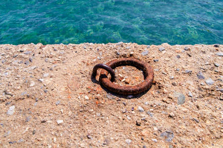 Old iron mooring cleat on a concrete pierの写真素材