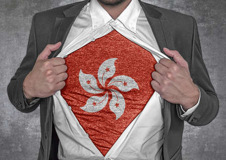 Business man show t-shirt flag of Hong Kong rips open his shirtの写真素材