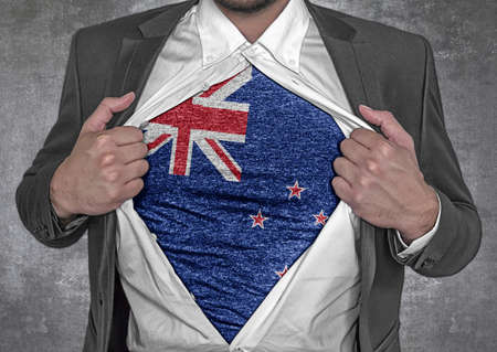 Business man show t-shirt flag of New Zealand rips open his shirtの写真素材
