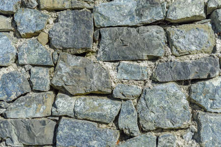 Design decorative uneven cracked real stone wall surfaceの写真素材