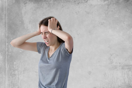 Angry young stressed businesswoman pulling her hairの写真素材