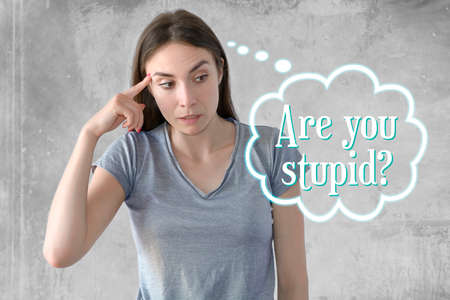 Emotion and gesture young woman written are you stupidの写真素材