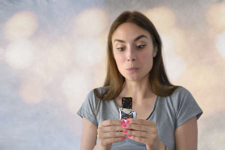 Portrait of a happy young woman looking chocolate barの写真素材