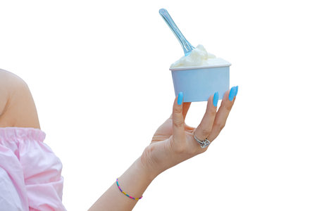 Hand of a girl holding neapolitan ice cream scoops in blue cup isolated on white