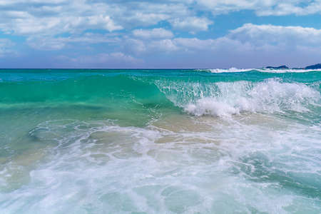 Big tropical ocean wave seashore with cloudy sky backgroundの写真素材