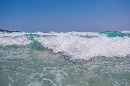 Big sea water wave comming with clean blue skyの写真素材