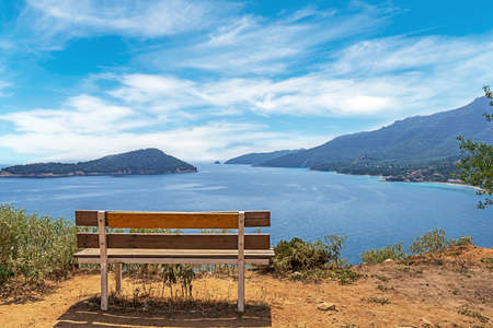 Old wooden bench looking out to the sea and islandsの写真素材