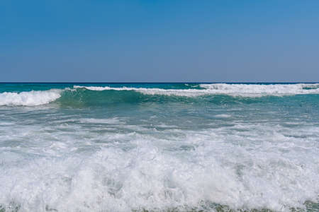 Several ocean foamy wave with blue clean skyの写真素材