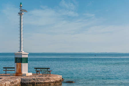 Small lighthouse on sea coast with cloudy sky backgroundの写真素材