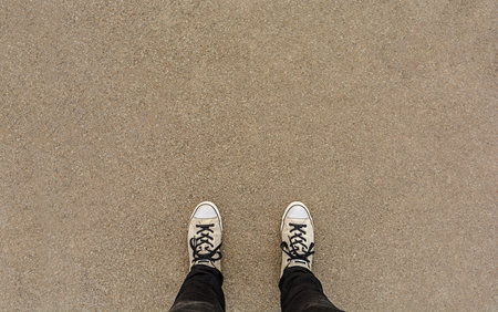 Pair of legs shoes on asphalt ground, high angle footsie or flortrait
