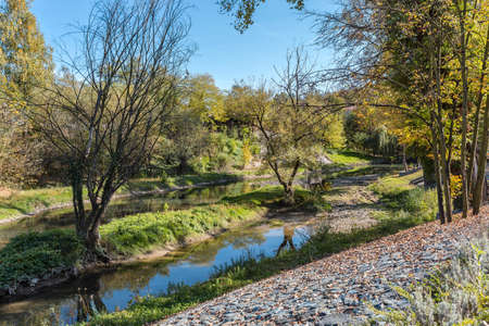 River in Banja Luka with blue and gray clear sky and the tree reflection on waterの写真素材