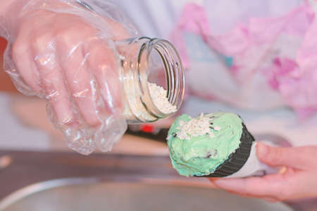 Small cube of white chocholate for ice cream pouring a black tasty cone in shopの写真素材