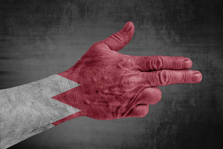 Bahrain flag painted on male hand like a gunの写真素材