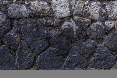 Very dark and old facade rusty pattern construction stone wall backgroundの写真素材