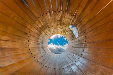 Wooden circle tube with cloudy sky at the endの写真素材