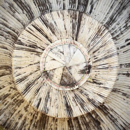 closeup on woven Thai hats hanging on a wooden wall の写真素材
