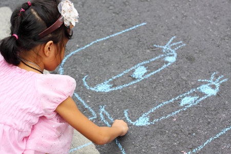 PHUKET, THAILAND - JANUARY 28: Unidentified girl drawing on asphalt with chalk in PHUKET CHINESE NEW YEAR FESTIVAL 2012 on January 28, 2012 in Phuket, Thailand.のeditorial素材