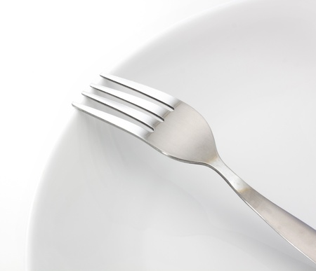 White plate, fork on light backgroundの写真素材