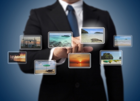 business man pushing virtual screen with different images of tropical sea , andamanの写真素材