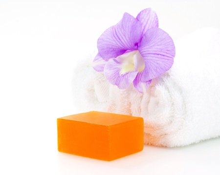Rolled white towel, soap and orchidの写真素材