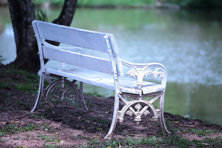 Lonely white bench in the park by the lagoonの写真素材