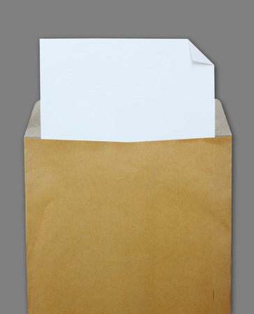 Opened brown envelope with white paper on grey backgroundの写真素材