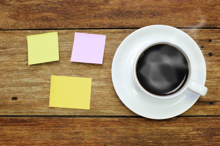 sticker note and a cup of coffee on wood table