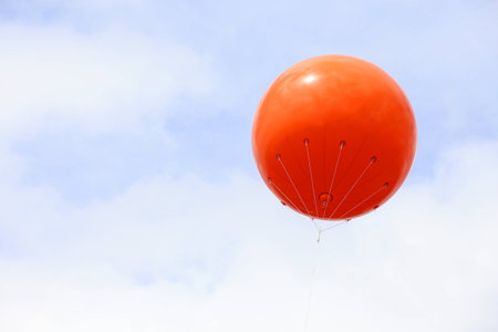 A blank orange balloon with space for text on skyの写真素材