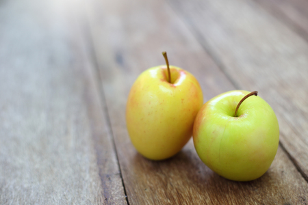 yellow apple on wood tableの写真素材