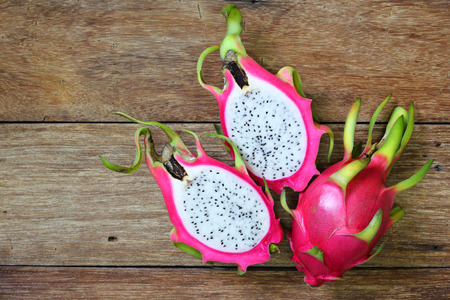 Juicy pink pitaya on wooden table closeupの写真素材