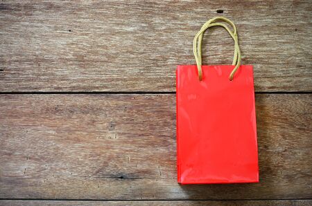 Red Paper bag on a wooden texture backgroundの写真素材
