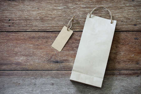 Price tag and paper shopping bag on wooden backgroundの写真素材