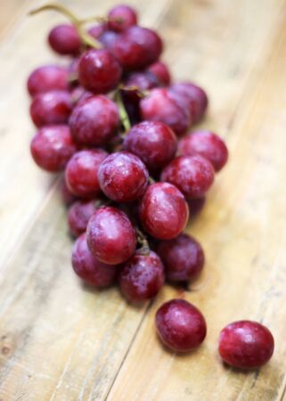 Red grapes on old wood table backgroundの写真素材