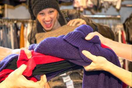 People contending colored clothes from the sales basket during the Christmas shopping.の写真素材