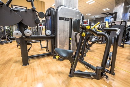 Panoramic interior view of modern equipment in the gym with mirrors on the walls, machines for sport, fitness and wellness.の写真素材